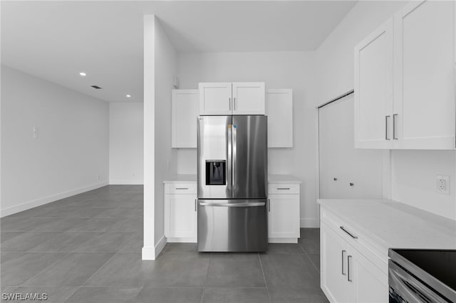 kitchen featuring tile patterned flooring, white cabinetry, light stone counters, and stainless steel refrigerator with ice dispenser