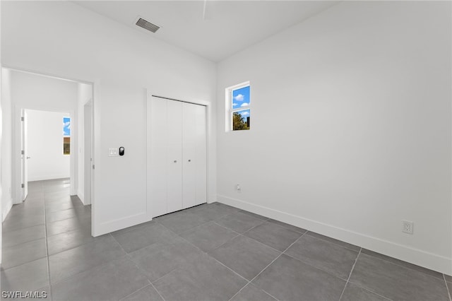 unfurnished bedroom with tile patterned floors and a closet