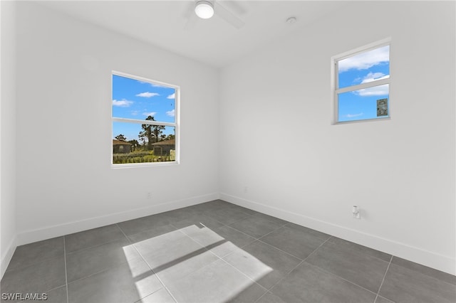 tiled spare room with ceiling fan