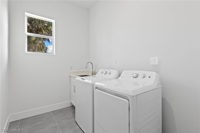 laundry room with sink, light tile patterned floors, separate washer and dryer, and cabinets