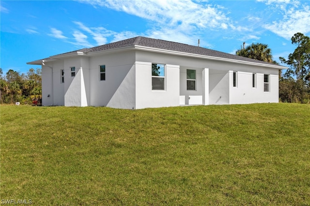 rear view of property featuring a lawn