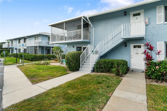 townhome / multi-family property with a balcony and a front yard