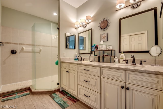 bathroom with double sink vanity, hardwood / wood-style floors, and an enclosed shower