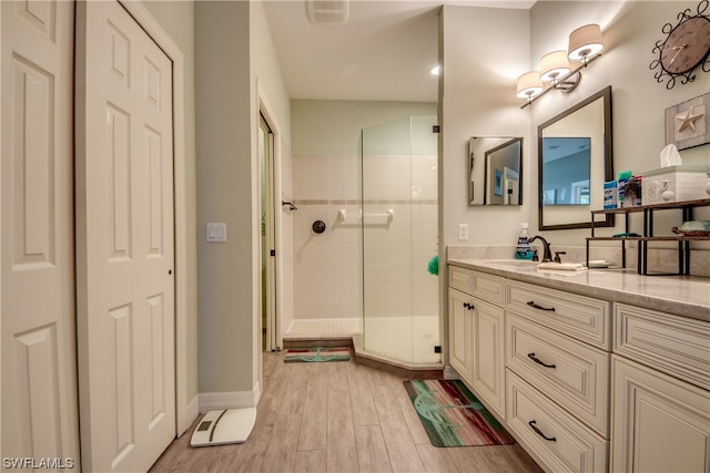 bathroom featuring an enclosed shower, hardwood / wood-style floors, and vanity