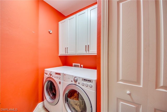 laundry room featuring washer hookup, cabinets, and washer and dryer