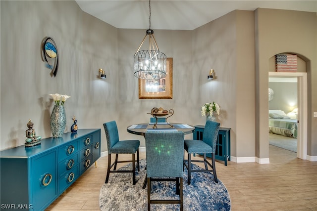 dining area with a notable chandelier and light hardwood / wood-style flooring