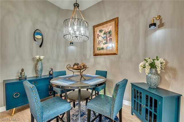 dining area with a notable chandelier and light hardwood / wood-style flooring