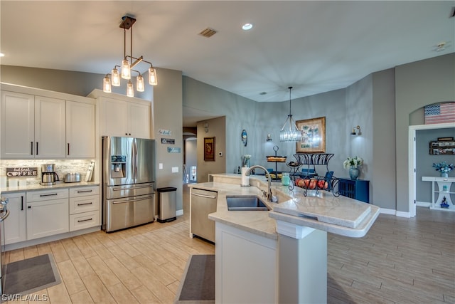 kitchen with white cabinets, pendant lighting, sink, and stainless steel appliances