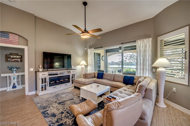 living room featuring vaulted ceiling, ceiling fan, and light hardwood / wood-style flooring