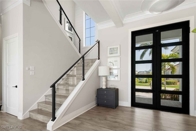 stairs with ornamental molding, beam ceiling, french doors, and wood-type flooring