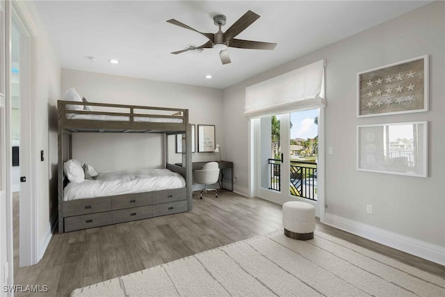 bedroom featuring access to outside, hardwood / wood-style flooring, multiple windows, and ceiling fan