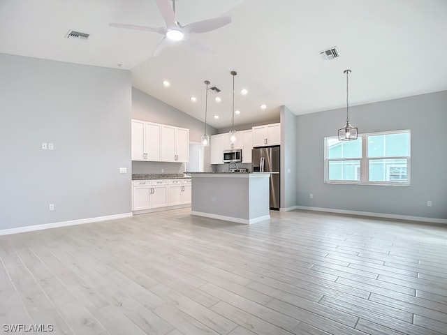 kitchen featuring white cabinets, an island with sink, appliances with stainless steel finishes, and light hardwood / wood-style flooring