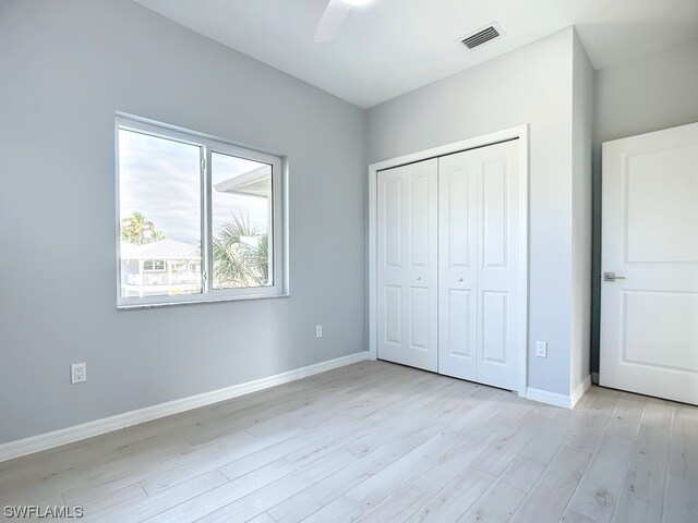 unfurnished bedroom with multiple windows, ceiling fan, and light hardwood / wood-style flooring