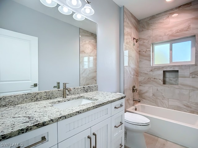 full bathroom with tiled shower / bath, toilet, hardwood / wood-style flooring, and vanity