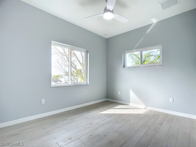 spare room featuring light hardwood / wood-style floors, ceiling fan, and a wealth of natural light