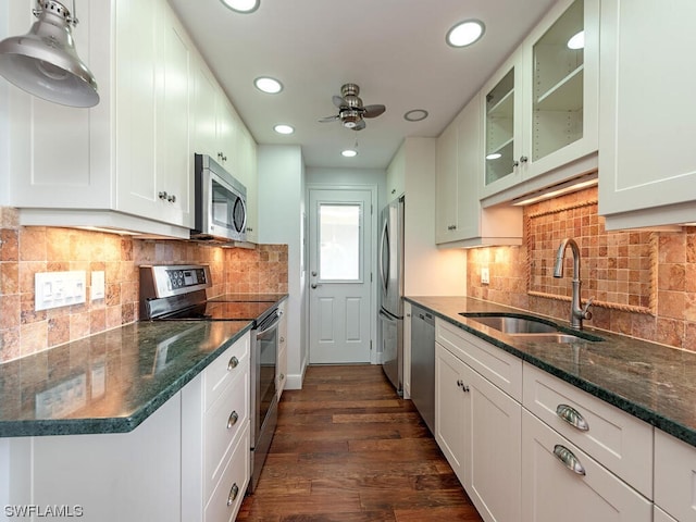 kitchen featuring ceiling fan, sink, appliances with stainless steel finishes, backsplash, and dark wood-type flooring