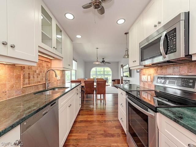 kitchen featuring hanging light fixtures, ceiling fan, appliances with stainless steel finishes, tasteful backsplash, and dark hardwood / wood-style flooring