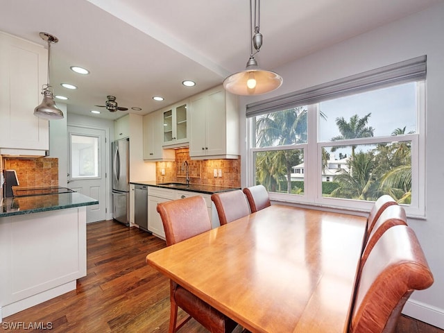 dining space with plenty of natural light, dark hardwood / wood-style floors, ceiling fan, and sink