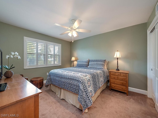 bedroom with light carpet, a closet, and ceiling fan