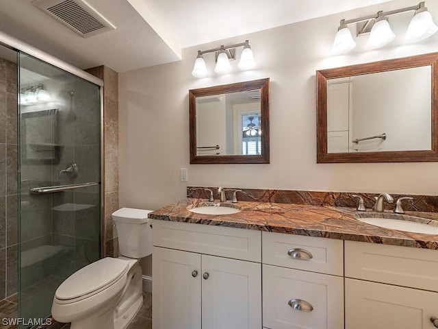 bathroom with toilet, large vanity, walk in shower, and double sink