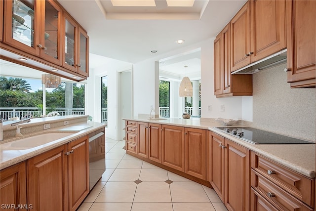 kitchen featuring sink, light tile floors, light stone counters, decorative light fixtures, and black electric stovetop