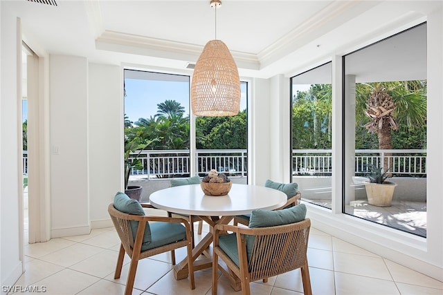 sunroom featuring an inviting chandelier, a tray ceiling, and a wealth of natural light