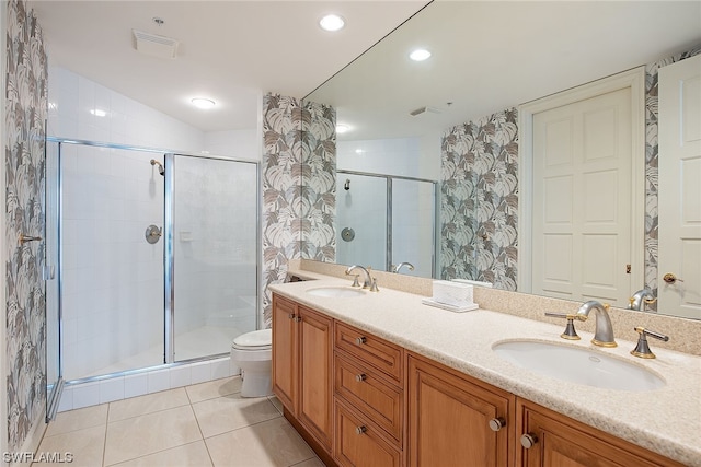 bathroom featuring toilet, a shower with door, dual sinks, tile flooring, and oversized vanity