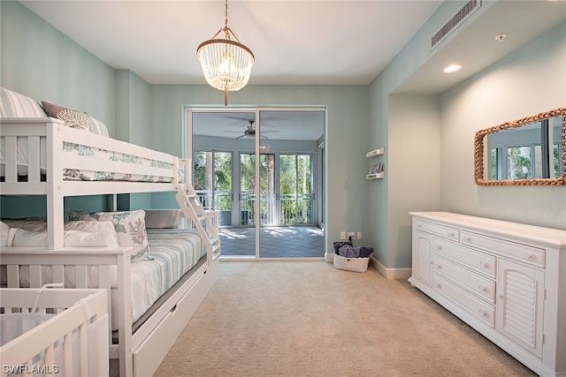 carpeted bedroom featuring access to outside and an inviting chandelier