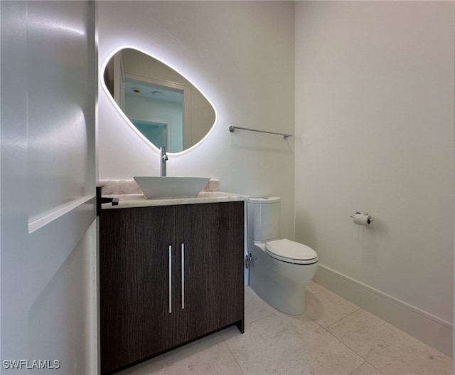 bathroom featuring tile patterned flooring, vanity, and toilet