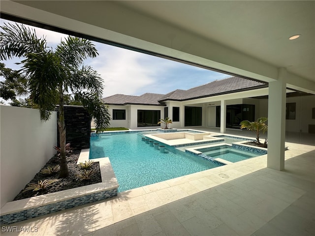 view of pool with a patio area and an in ground hot tub