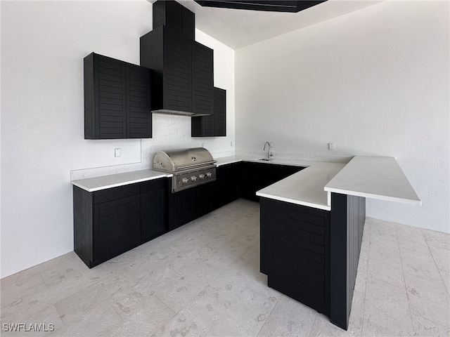 kitchen with a breakfast bar area, sink, kitchen peninsula, and light tile patterned flooring