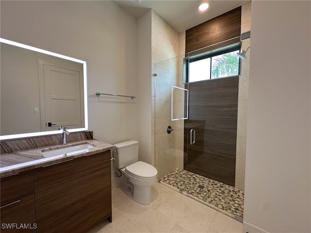 bathroom with a shower with door, vanity, toilet, and tile patterned floors