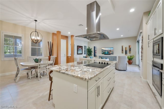 kitchen featuring island exhaust hood, stainless steel appliances, pendant lighting, white cabinets, and a center island