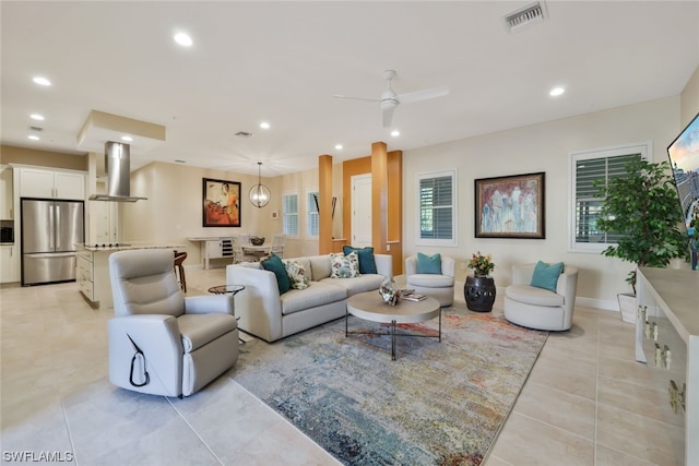 tiled living room with ceiling fan and a healthy amount of sunlight