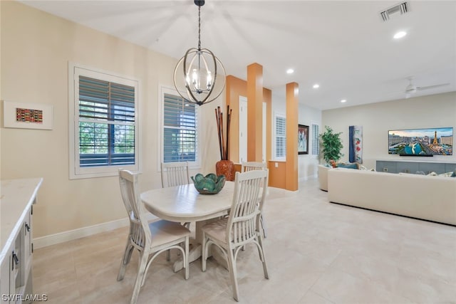 dining space with ceiling fan with notable chandelier