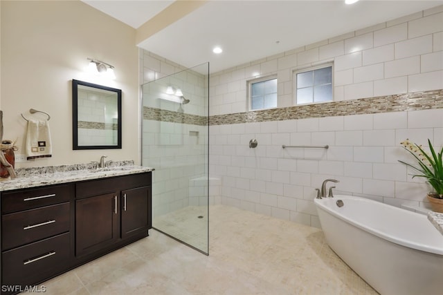 bathroom featuring vanity, tile patterned floors, tile walls, and independent shower and bath