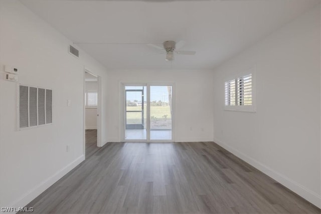 spare room featuring plenty of natural light, ceiling fan, and wood-type flooring