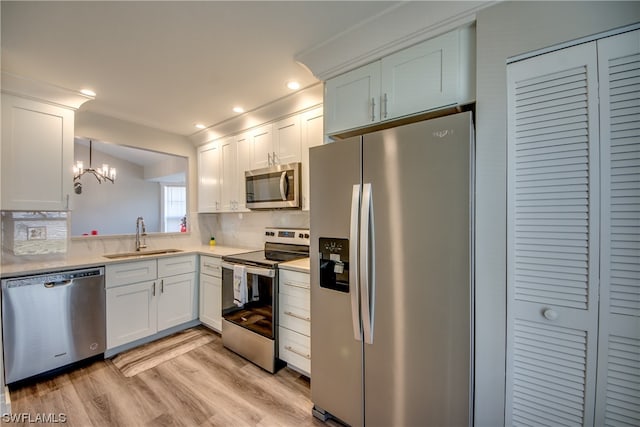 kitchen featuring backsplash, light hardwood / wood-style flooring, appliances with stainless steel finishes, and sink