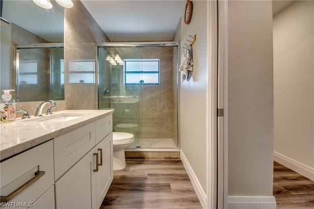 bathroom featuring an enclosed shower, toilet, large vanity, and hardwood / wood-style flooring