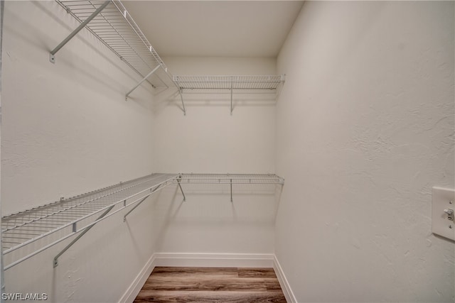 walk in closet with light hardwood / wood-style floors