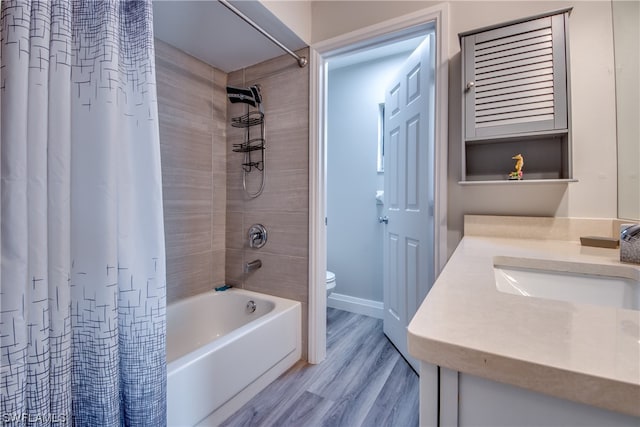 full bathroom featuring shower / bath combo with shower curtain, toilet, hardwood / wood-style flooring, and vanity