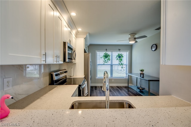 kitchen with stainless steel appliances, ceiling fan, white cabinetry, and sink