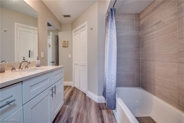 bathroom featuring shower / bath combination with curtain, hardwood / wood-style floors, and vanity