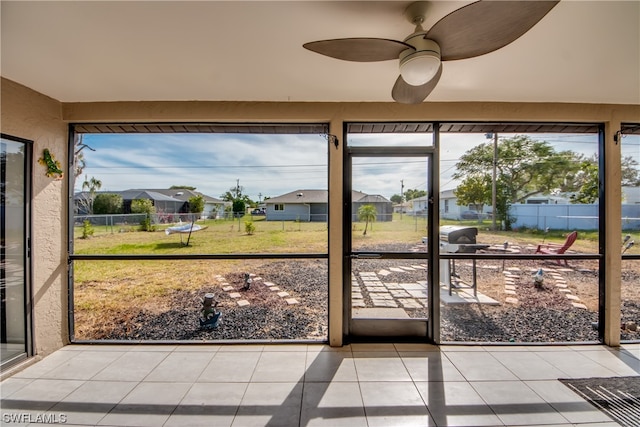 unfurnished sunroom featuring ceiling fan