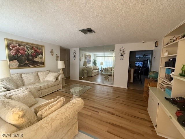 living room with light hardwood / wood-style floors and a textured ceiling