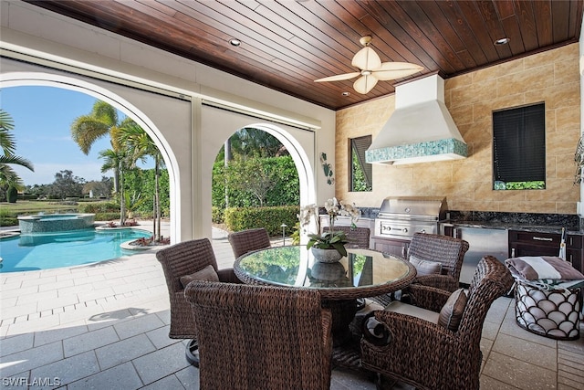 view of patio / terrace with ceiling fan, a pool with hot tub, grilling area, and exterior kitchen