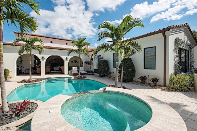 view of pool with an in ground hot tub and a patio area