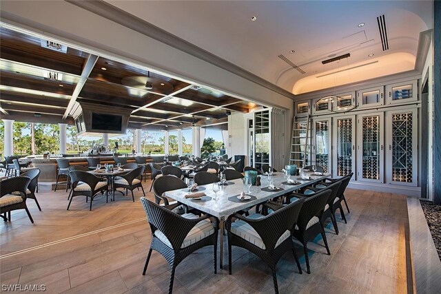 dining room with wood-type flooring and coffered ceiling