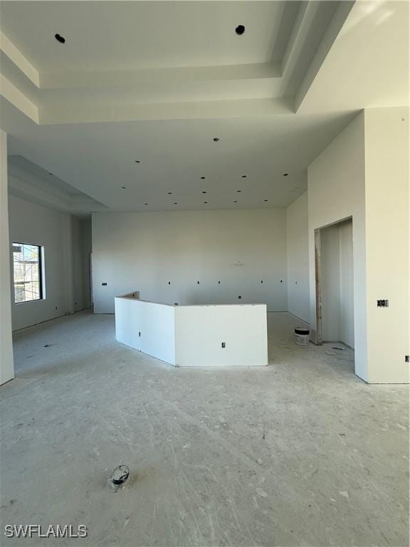 unfurnished room with a towering ceiling and a raised ceiling