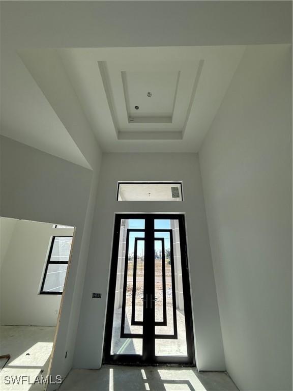 foyer entrance with a tray ceiling and french doors